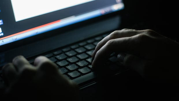 A survey of parents and teachers found that online misogynistic comments have been making their way into classrooms in Canada. A closeup shows hands on a computer keyboard in a darkened room.
