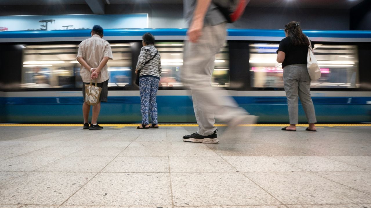Low angle shot of commuters waiting for metro to stop at the platform.
