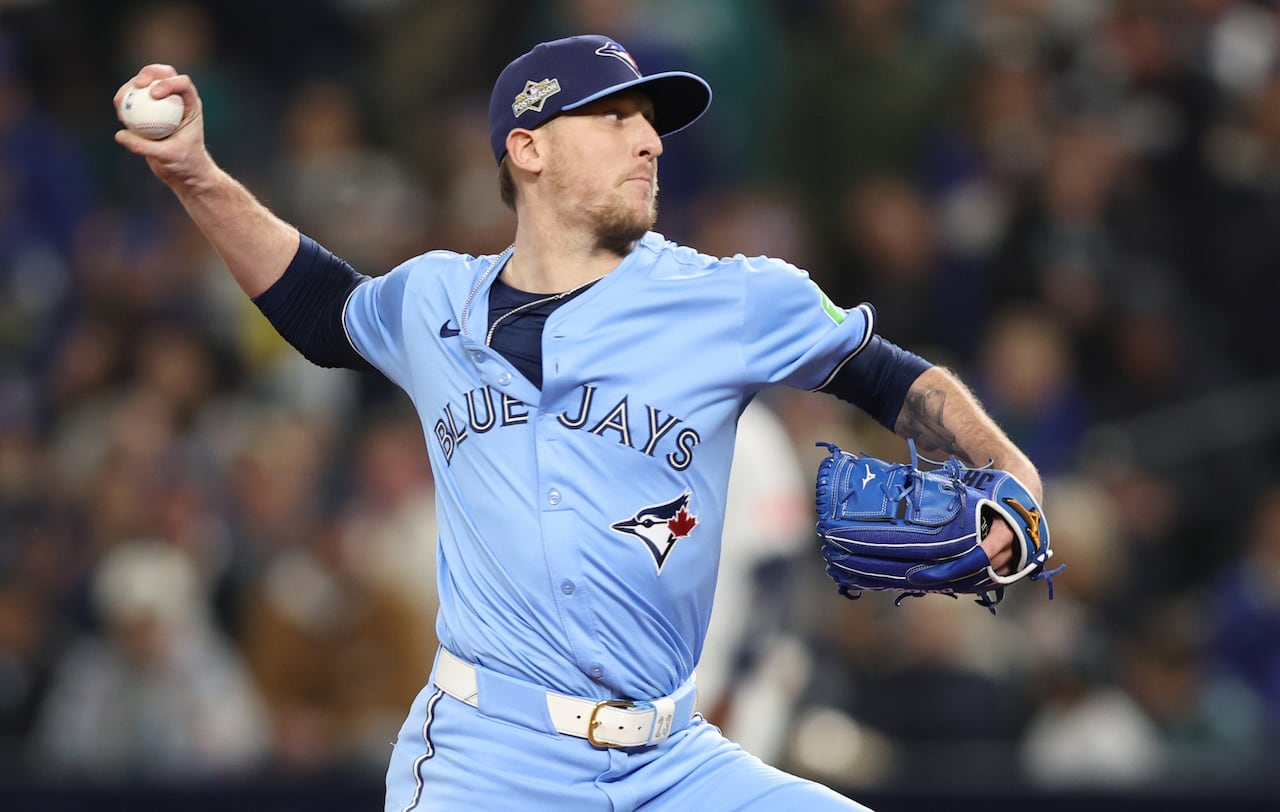 A man in a baseball uniform throws a baseball.