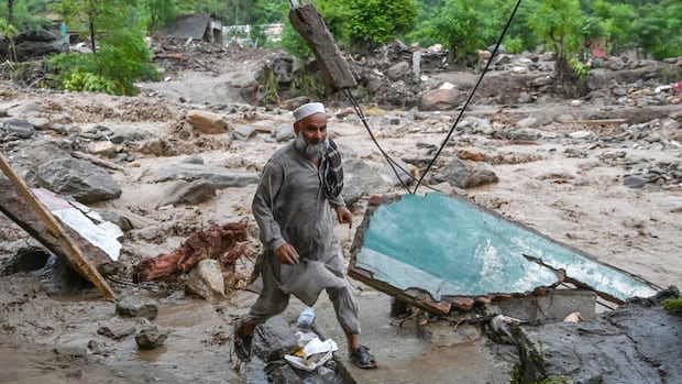 A resident evacuates the area following a rise in floodwaters in the Buner district of Pakistan's Khyber Pakhtunkhwa province on August 18, 2025.