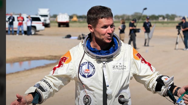 elix Baumgartner of Austria gestures prior to speaking with the media after successfully jumping from a space capsule lifted by a helium balloon in Roswell, N.M., Oct. 14, 2012 A man in a space suit with his arms open wide