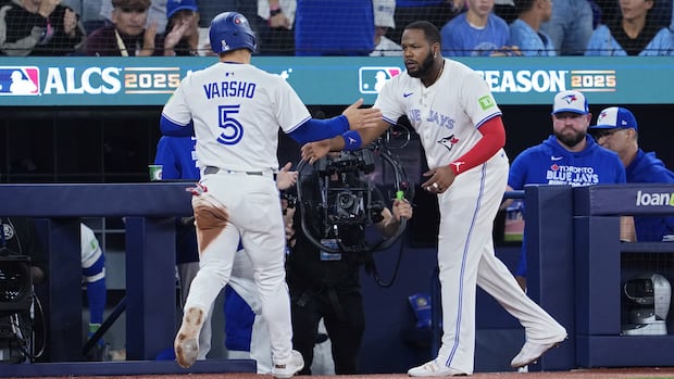 Two baseball players give each other a high-five.