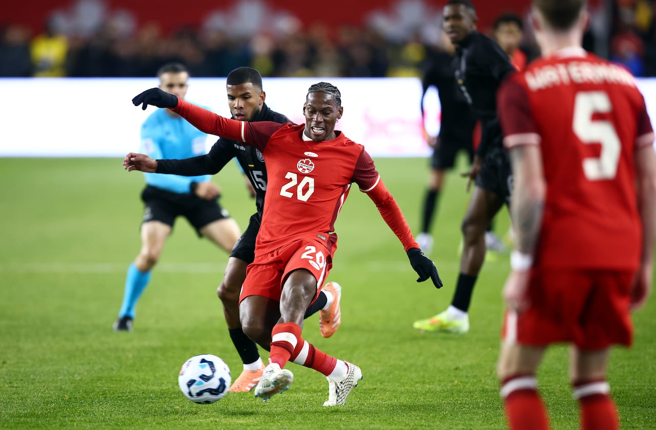Two soccer players battle for the ball.