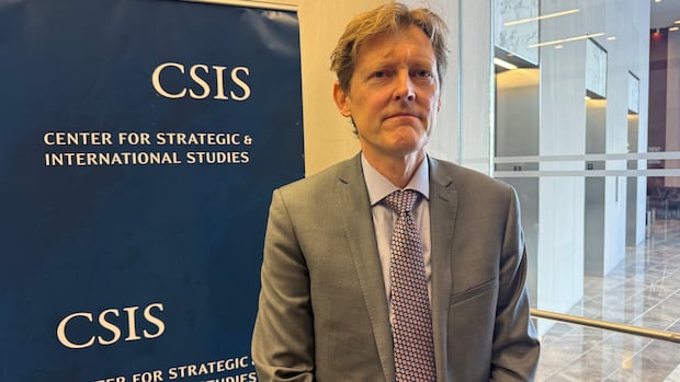 Tim Sargent stands in front a blue banner that says 'Center for Strategic & International Studies.' 
