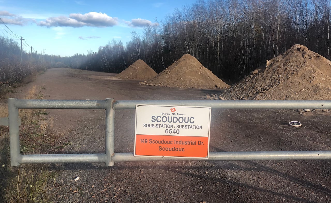 a gravel roadworthy with respective piles of gravel successful the distance, and a metallic gross barring entree with a motion speechmaking Scoudouc substation, 149 Scoudouc Industrial Drive