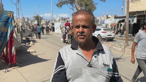 A man speaks on a busy street.