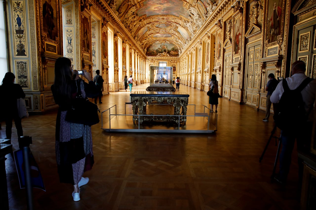People take pictures with their phones in the museum.