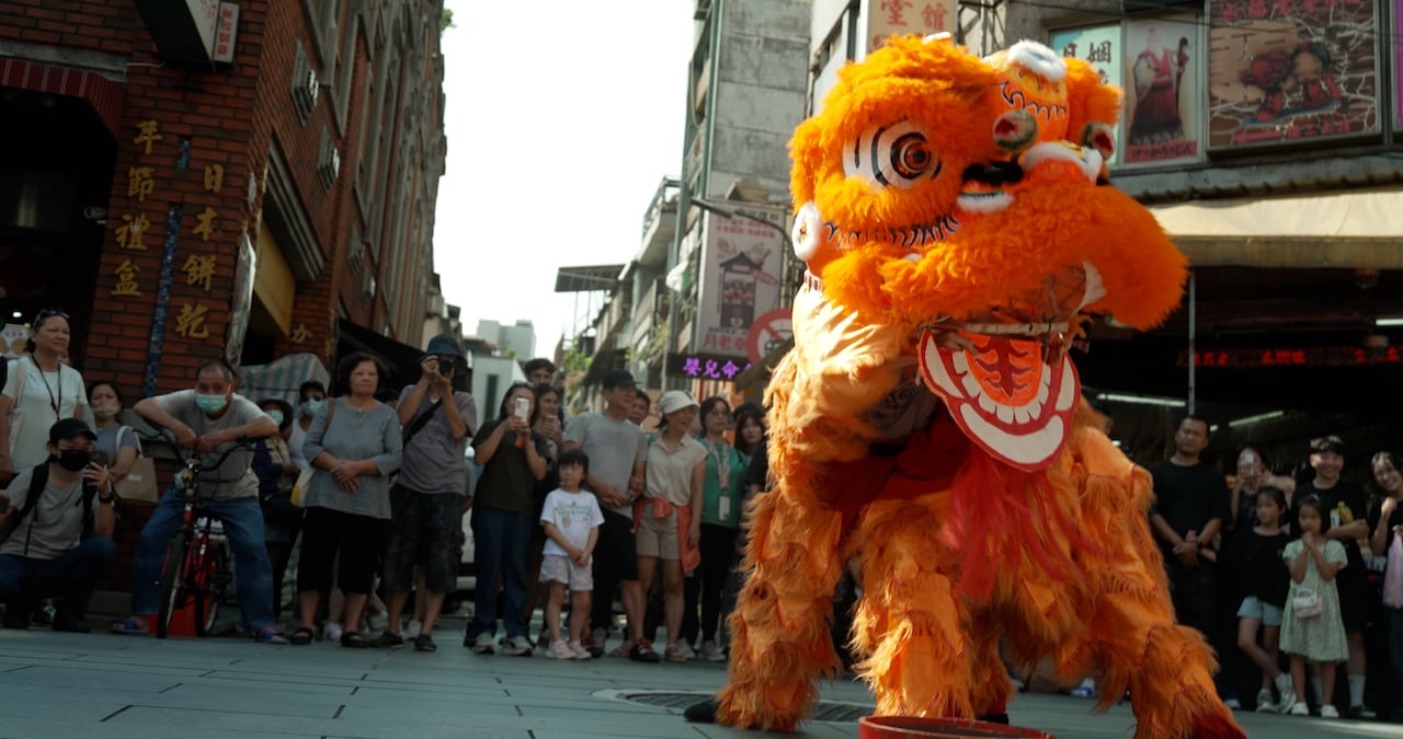 People stand outside they look for a big orange creature