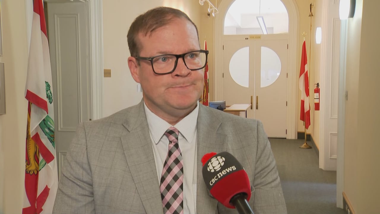 A antheral   successful  a grey suit   and a pinkish  checkered tie.
