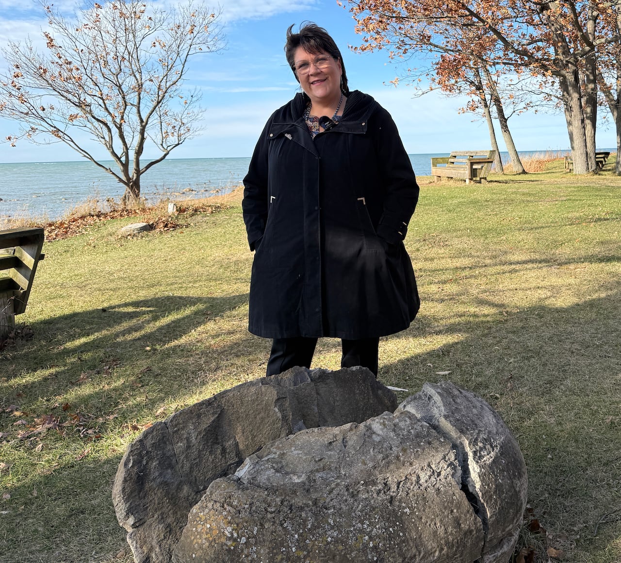 Mulher fica com grande chaleira de pedra no lago.