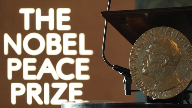 A replica of the Nobel Peace Medal is placed at the Norwegian Nobel Institute, where the laureate of the Nobel Peace Prize is announced, in Oslo, Norway, October 10, 2025. REUTERS/Tom Little A large coin with the portrait of a man is shown, near wording on a backdrop that reads, The Nobel Peace Prize.