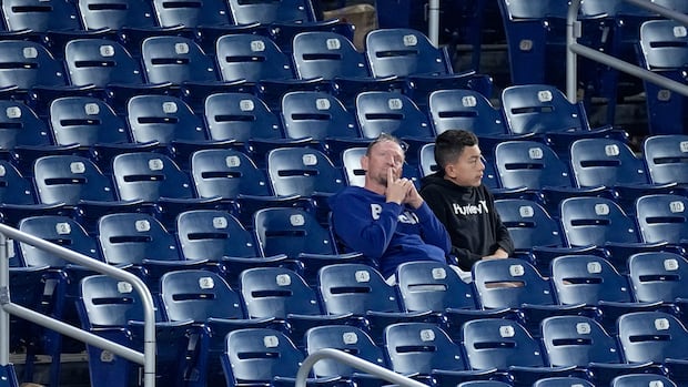 two fans sit in an otherwise empty stand.
