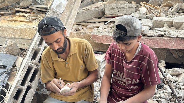 The two men have been searching for Masa's remains in the rubble of the building she was sheltering in with her family two men sit in rubble and hold a white shoe