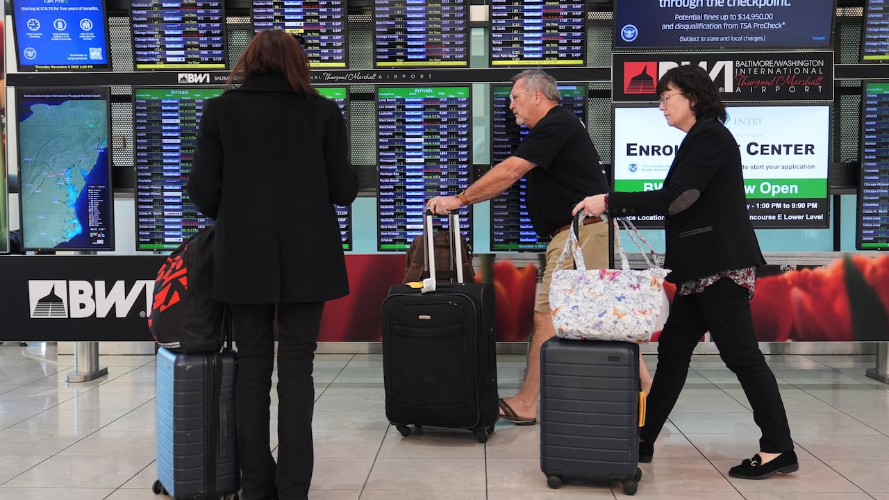 A traveler at an airport checks the flight information board.