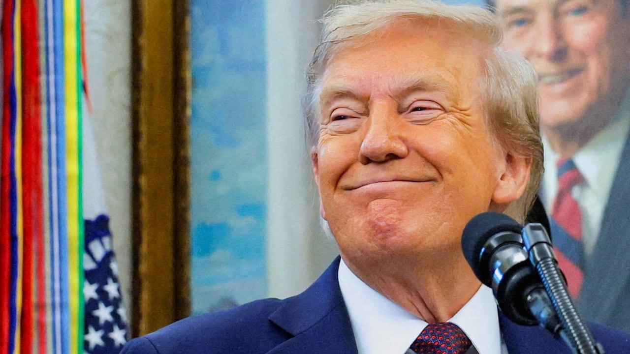 A man in a suit smiles.