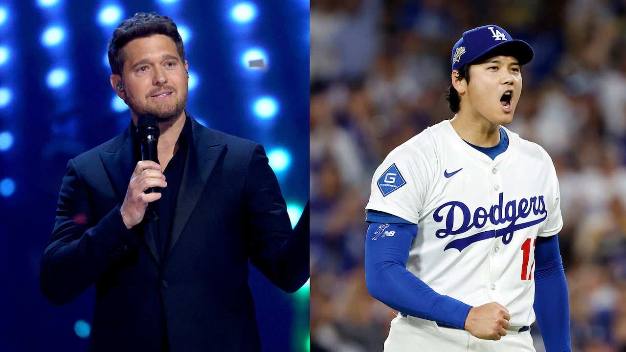Michael stands in a black suit holding a mic and speaking into it. Shohei Ohtani cheers while wearing his Dodgers uniform.