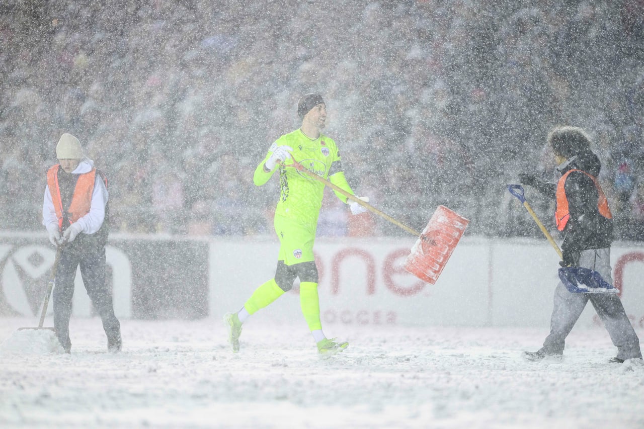 Atletico Ottawa's Nathan Ingham (29) carries a snow shovel following a break in play as officials work to clean soccer pitch lines during first half Canadian Premier League finals soccer action in Ottawa, on Sunday, Nov. 9, 2025