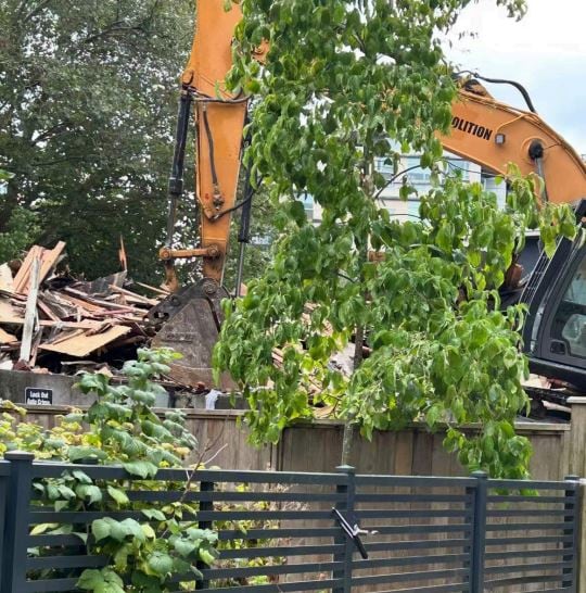An excavator demolishes a building