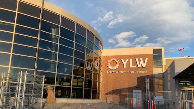 The Kelowna International Airport is pictured in a file photo. The exterior of a stone and glass building with a sign reading, 'YLW Kelowna International Airport.'