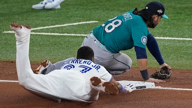 A baseball player slides onto a base.
