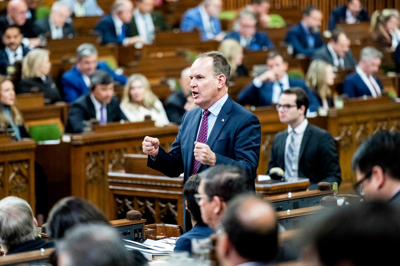 A man in a suit standing in the House of Commons.