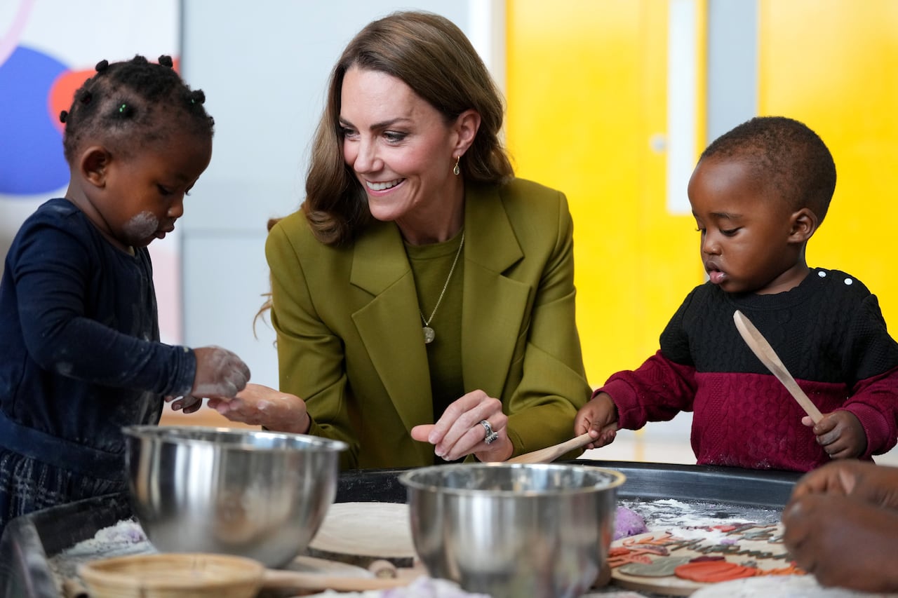 An adult and two children sit at a baking station.