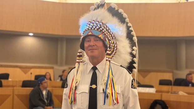A man is wearing a uniform while donning a feathered headdress.
