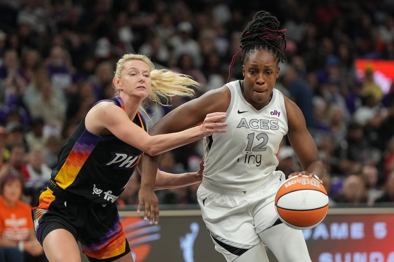 A basketball player attempts to dribble past a defender.