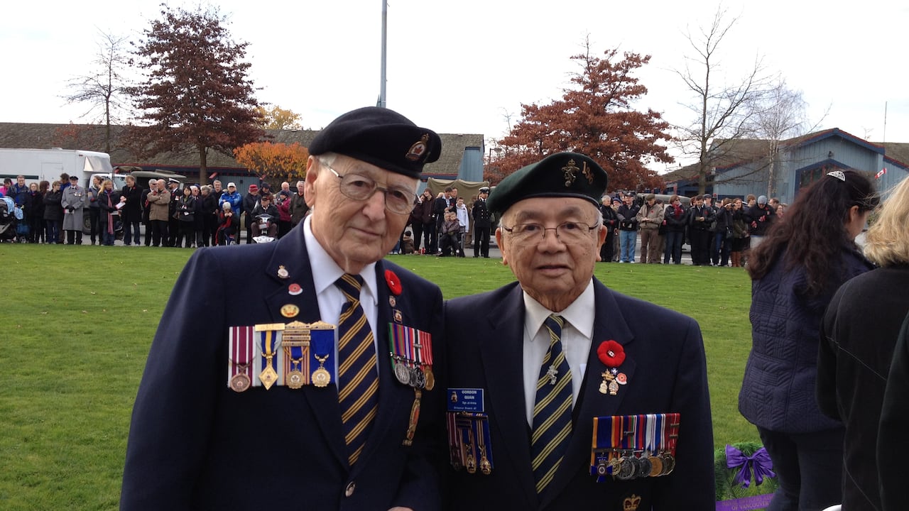 Two men in veteran suits with awards and medals are pictured.