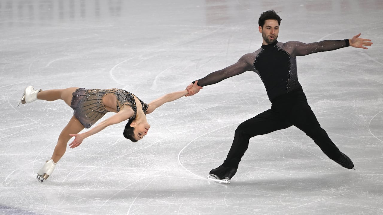 A pairs figure skating team performs a spin.