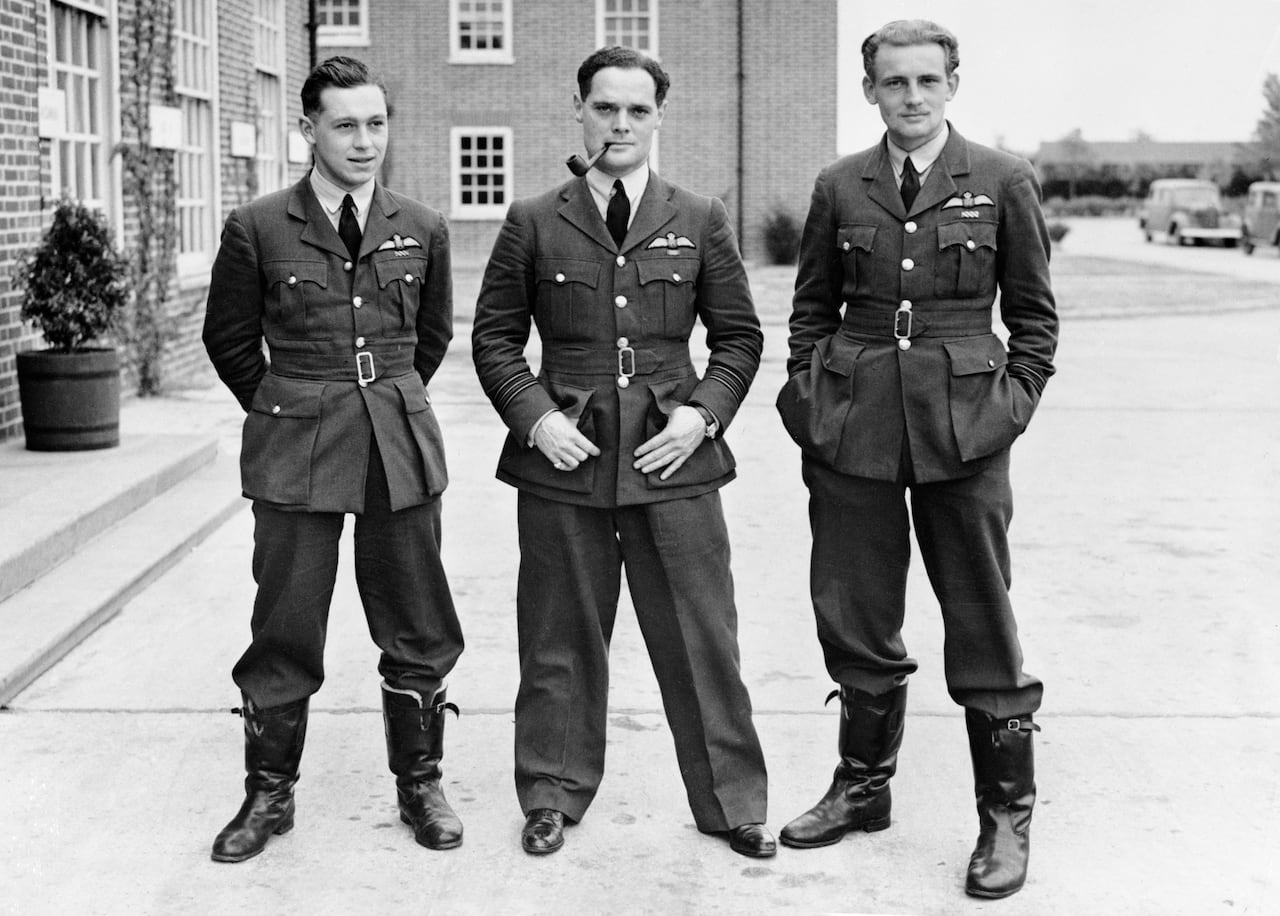 Three people stand in a row.