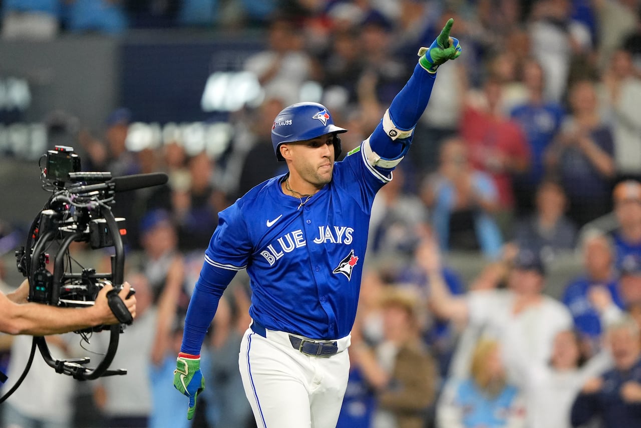 A baseball player points his index finger in the air