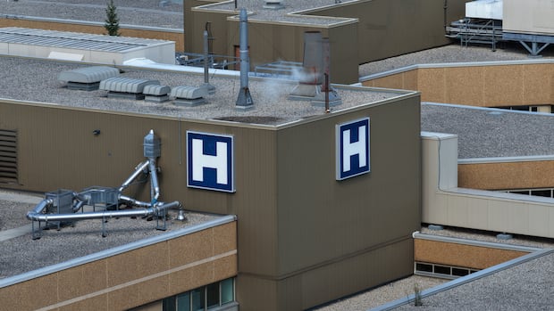 The rooftop of a hospital with a large blue "H" sign