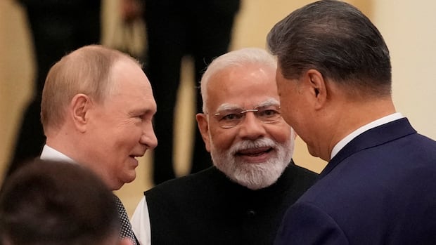 Three leaders are photographed in the conversation, they appear involved and smile in an official environment. Mood is friendly and cooperative.