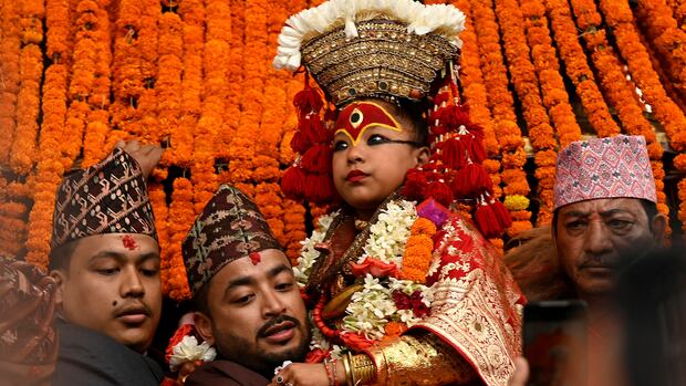 Living Goddess Kumari Trishna Shakya is presented in front of the crowd while being carried into her chariot during the annual Indra Jatra festival to worship Indra, Kumari and other deities and to mark the end of monsoon season in Kathmandu, Nepal September 17, 2024. REUTERS/Monika Malla child in costume held by men
