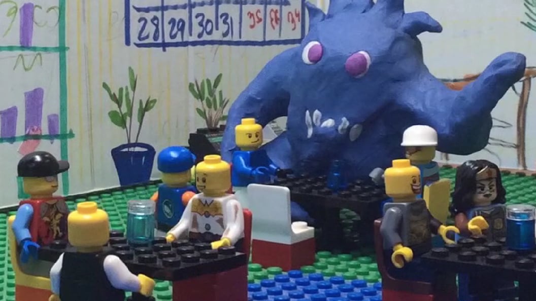 A close up of a clay monster known as The Puddle Monster and lego figures around it 