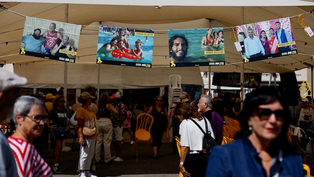 People gather at Hostages Square, after a ceasefire between Israel and Hamas in Gaza went into effect, in Tel Aviv, Israel, Oct. 10, 2025. People gather in a square where a banner displays photo of missing people