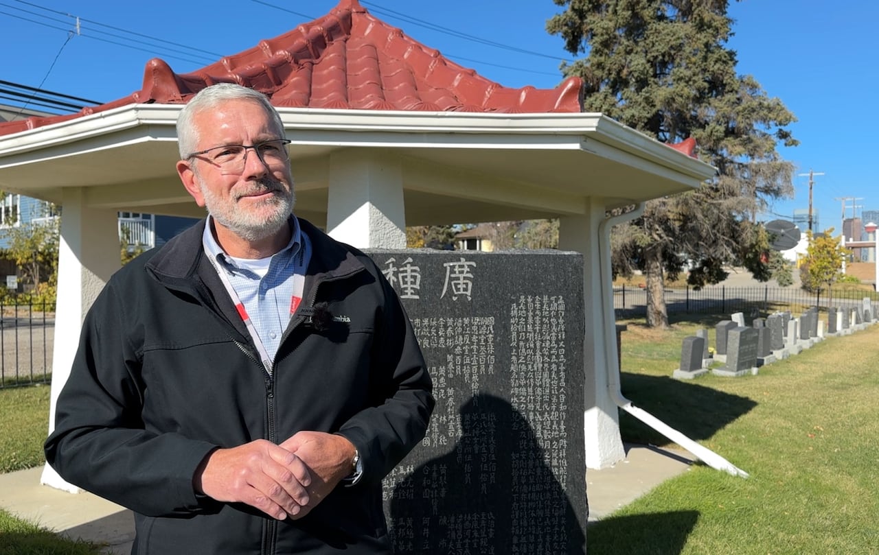 Gary Daudlin stands in front of the memorial.
