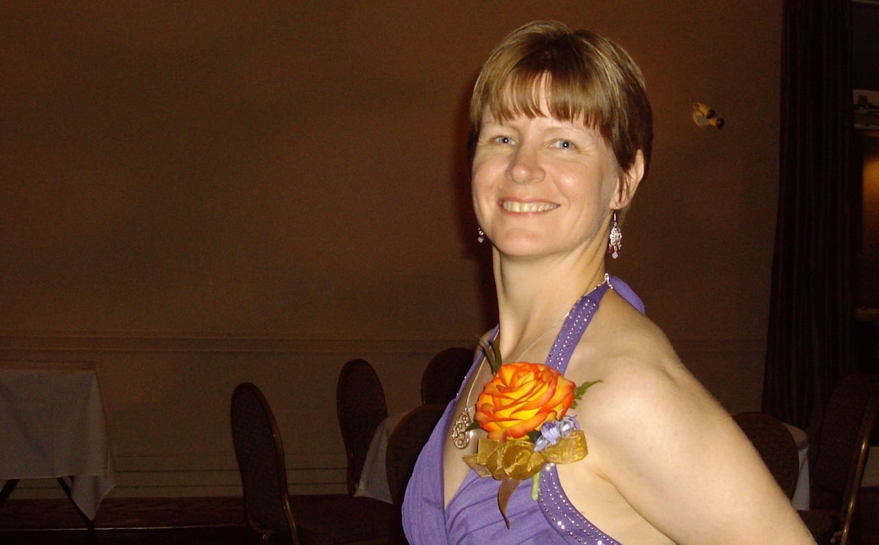 A woman in a dress, smiling.