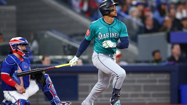 A baseball player watches his home run during a game.