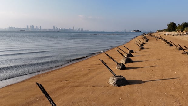 The view of Xiamen, China from Taiwan's Kinmen Islands,  just a few kilometres across the bay. Kinmen's beaches are covered with relics from past conflicts, including anti-tank defences. The view of Xiamen, China from Taiwan's Kinmen Islands,  just a few kilometers across the bay.   Kinmen's beaches are covered with relics from past conflicts,  including anti-tank defences.