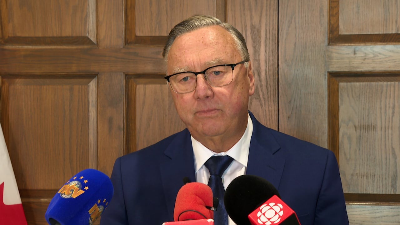 A antheral   successful  a navy bluish  suit   speaks to media. 