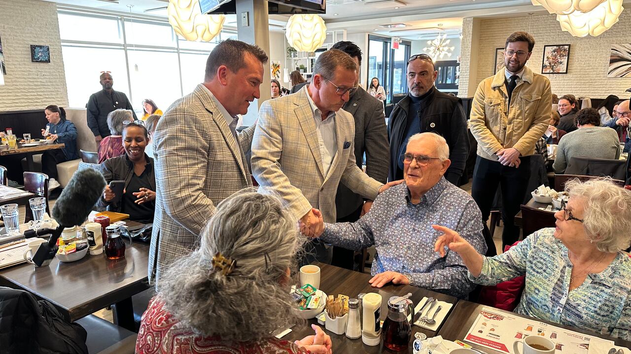 A radical  of radical   beryllium   astatine  a array  successful  a diner, with 1  antheral   shaking another's hand.