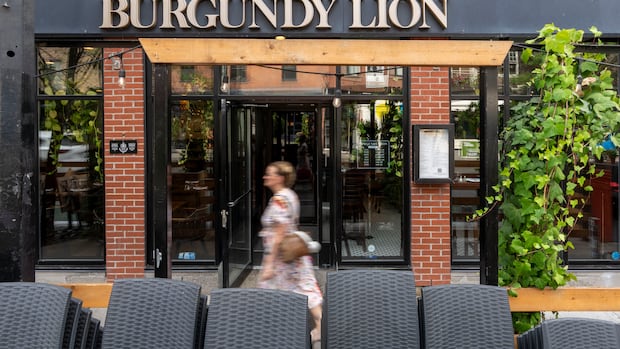Exterior shot of Pub Burgundy Lion that shows its outdoor signage and its terrace.