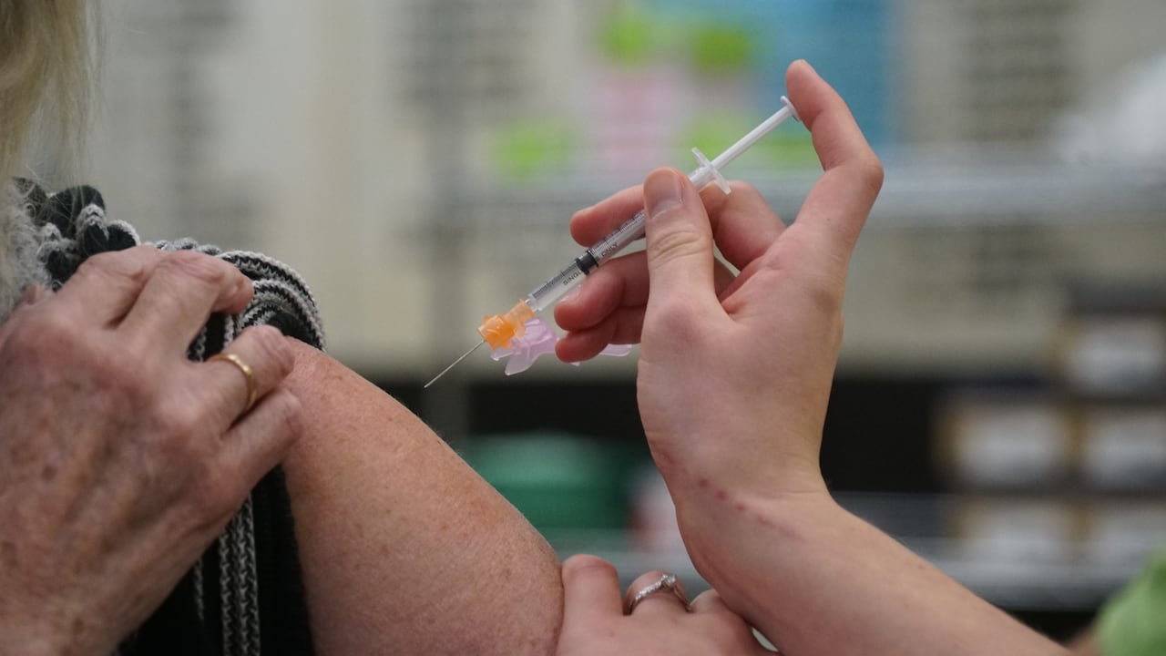 A woman getting a vaccine in her upper arm